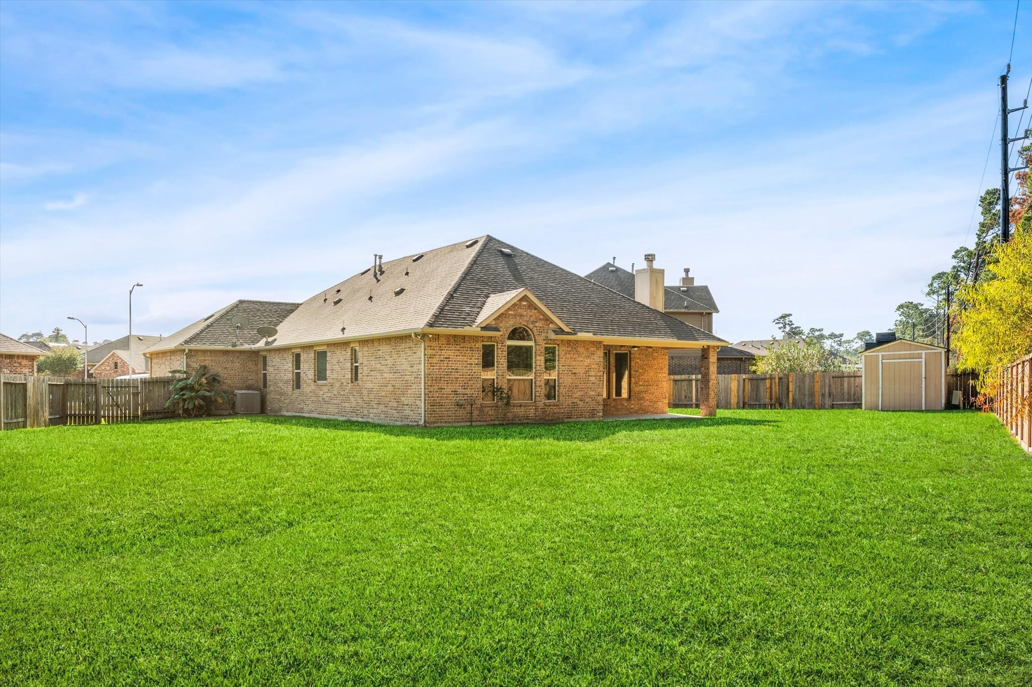 18130 Millau Viaduct Way Houston, TX 77044 - Photo 40 of 50 a house that is sitting in the grass with large trees and sky view