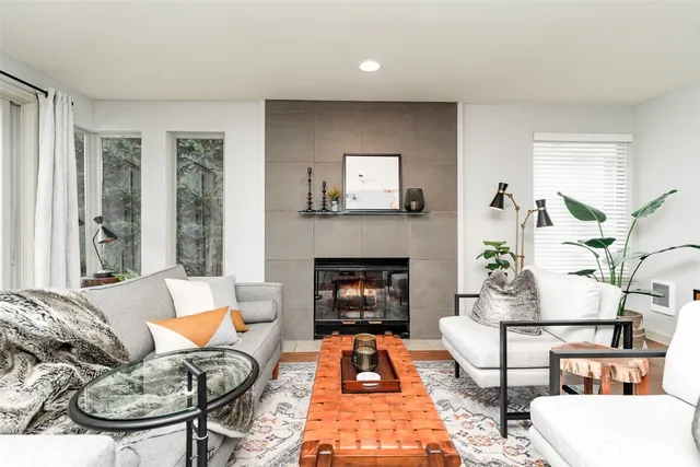 a living room with furniture a fireplace and a large window