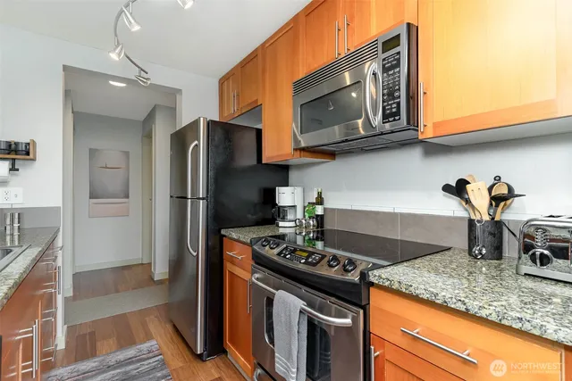 a kitchen with stainless steel appliances granite countertop a stove microwave and refrigerator