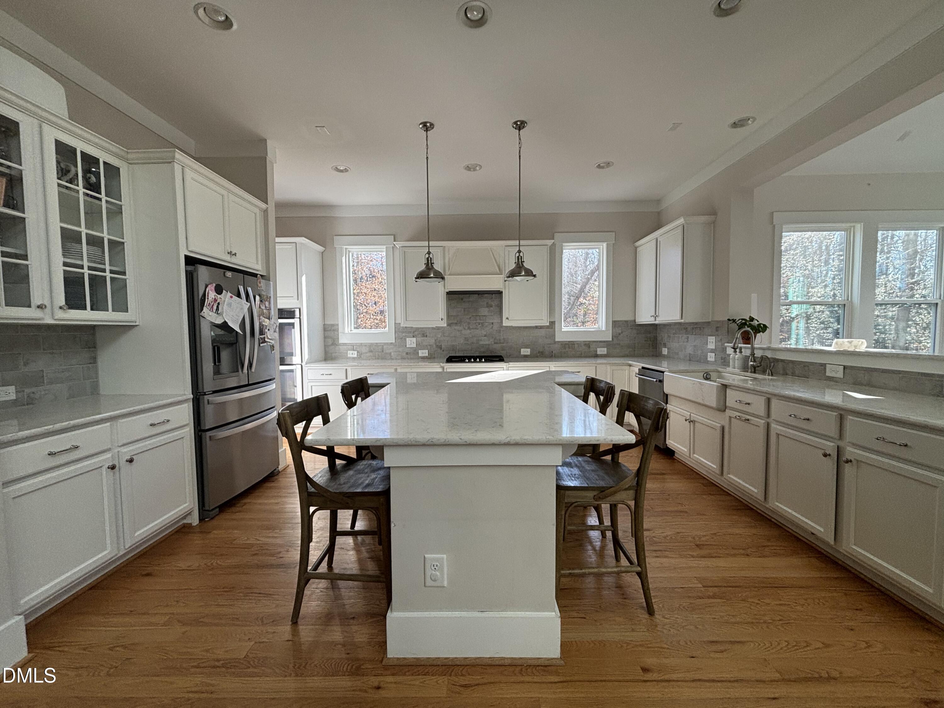 3939 River Stone Road Durham, NC 27705 - Photo 6 of 9 a kitchen with granite countertop a stove a sink dishwasher a refrigerator and cabinets with wooden floor