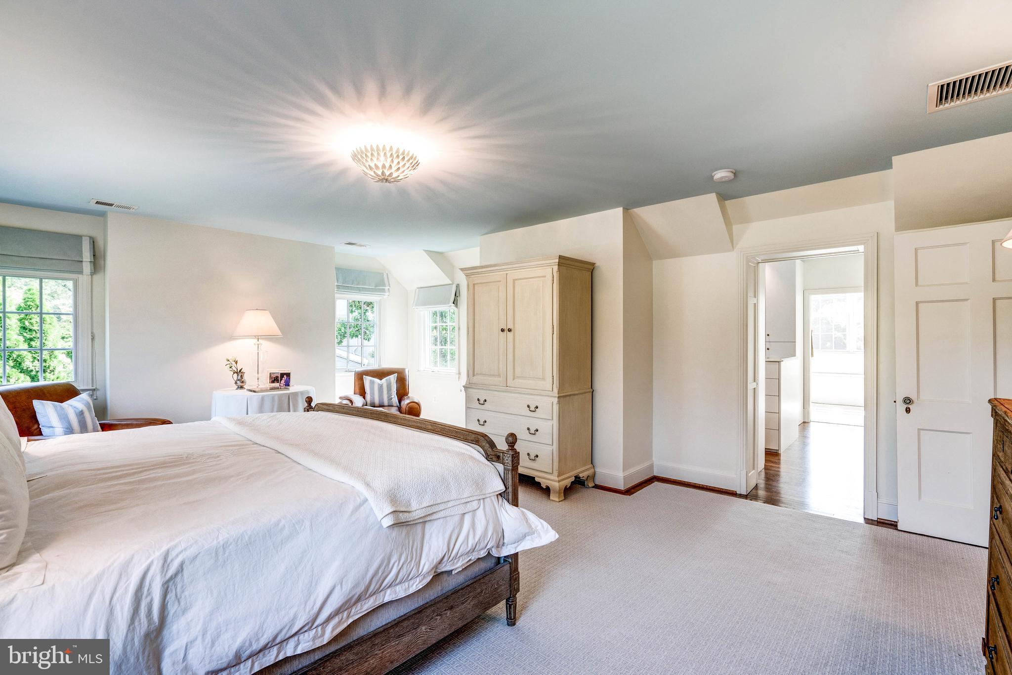 4509 Wetherill Road Bethesda, MD 20816 - Photo 43 of 89 a spacious bedroom with a bed and a chandelier