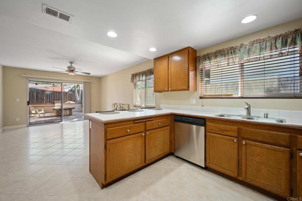 228 Ocotillo Place Oceanside, CA 92057 - Photo 13 of 31 a large kitchen with kitchen island a sink stainless steel appliances and cabinets
