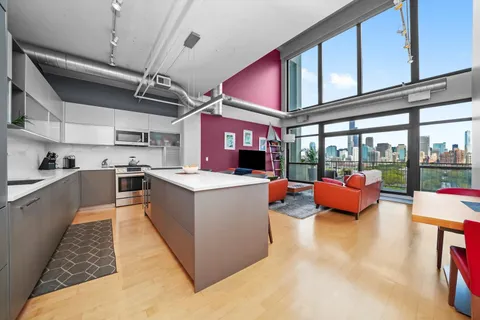 a large kitchen with stainless steel appliances kitchen island granite countertop a lot of cabinets and a couch