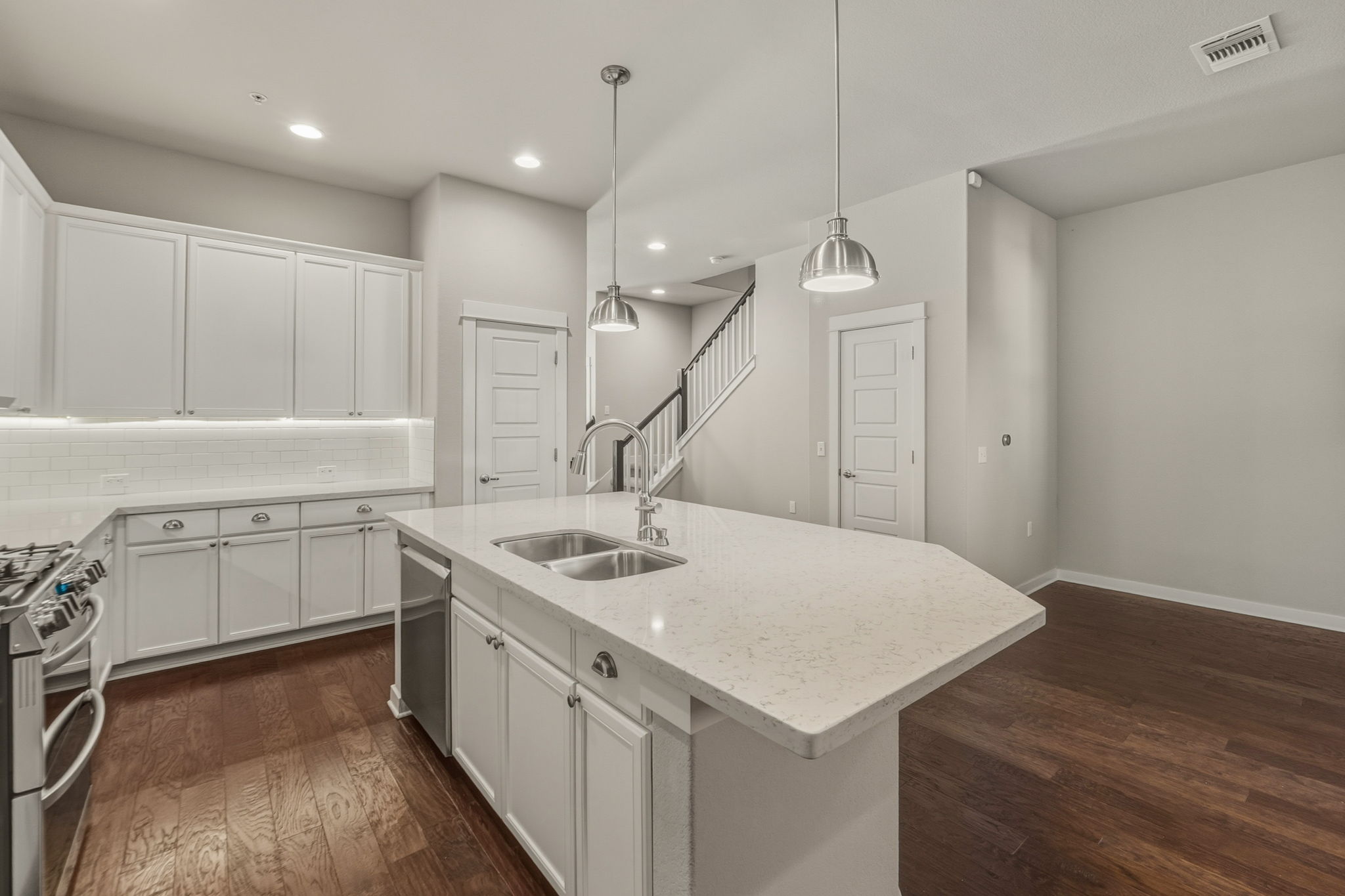 3919 Vaughan Street Austin, TX 78723 - Photo 12 of 40 A well-appointed kitchen showcasing a central island with a double sink and ample cabinetry.