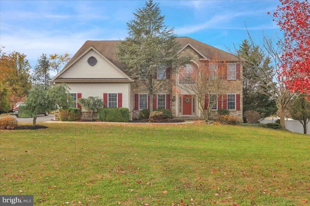 a view of a house with a big yard and large trees