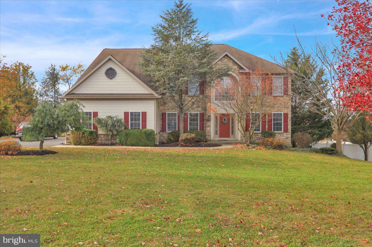 a front view of house with yard and ocean