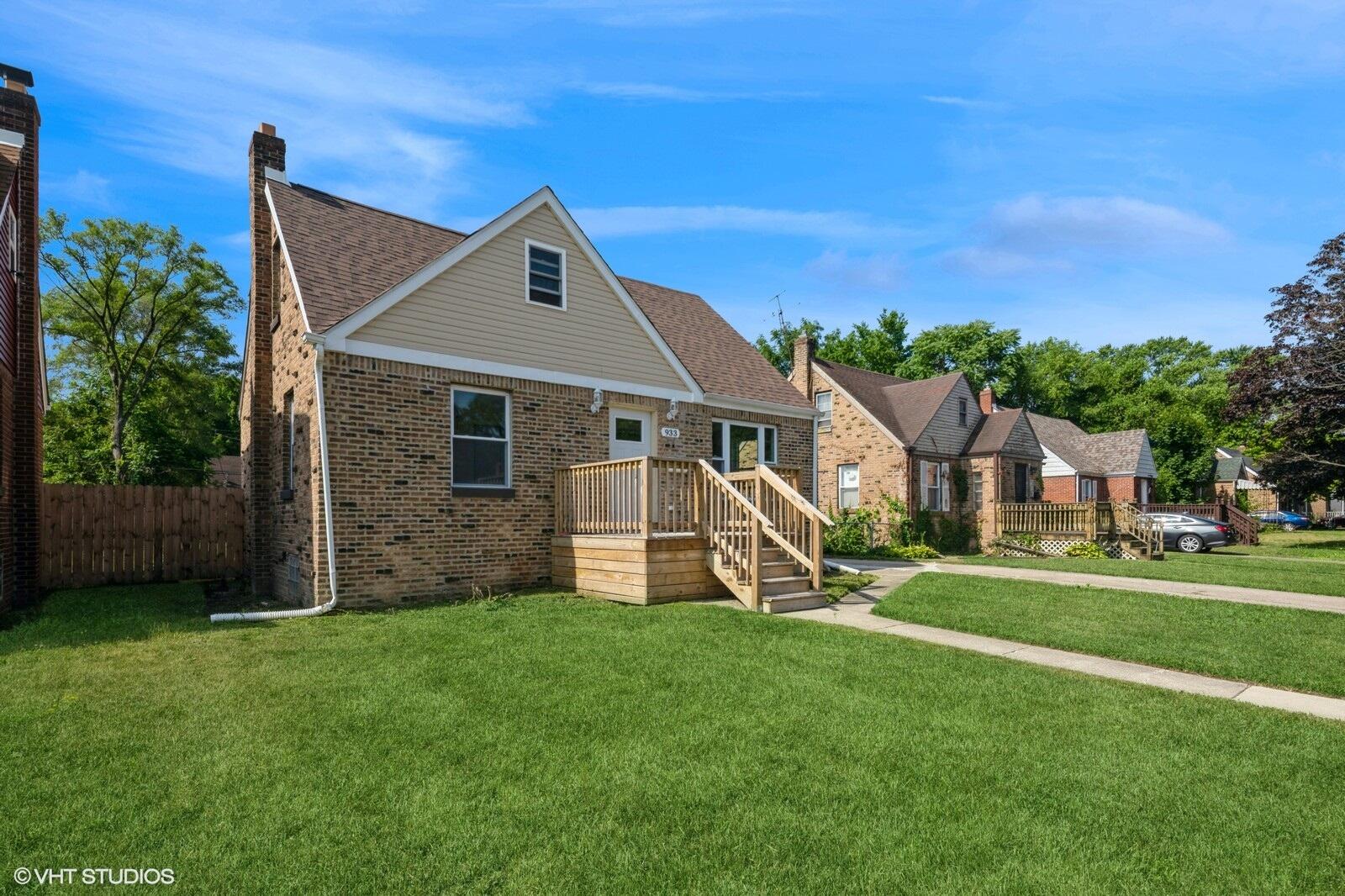 a front view of a house with a yard and green space
