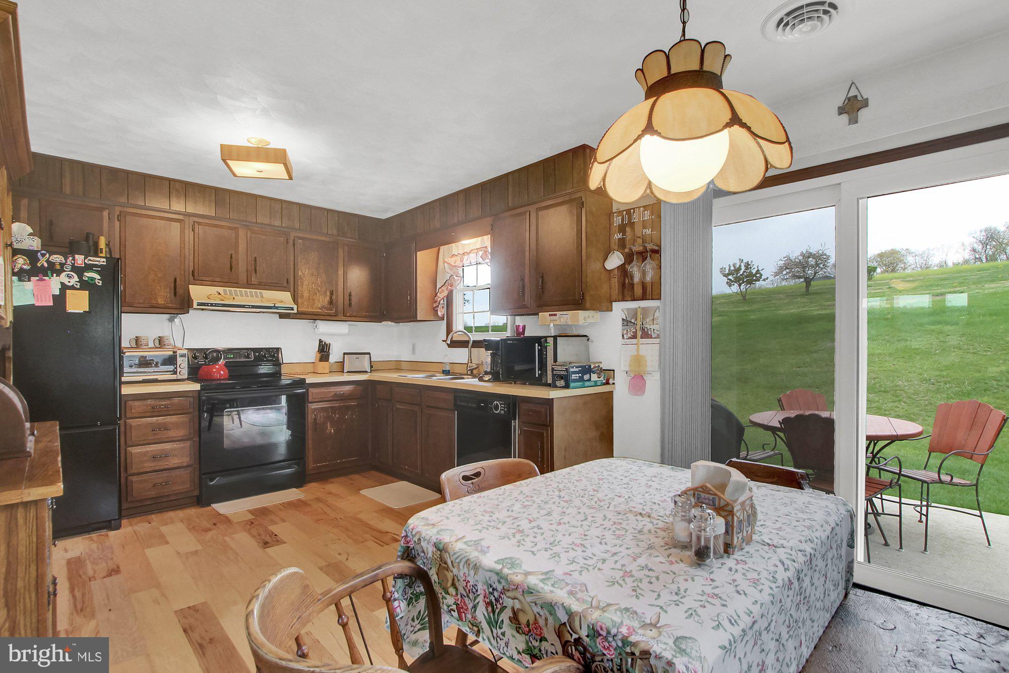 922 Hobart Road Hanover, PA 17331 - Photo 9 of 28 a kitchen with stainless steel appliances granite countertop a stove a refrigerator a sink dishwasher a dining table and chairs with wooden floor