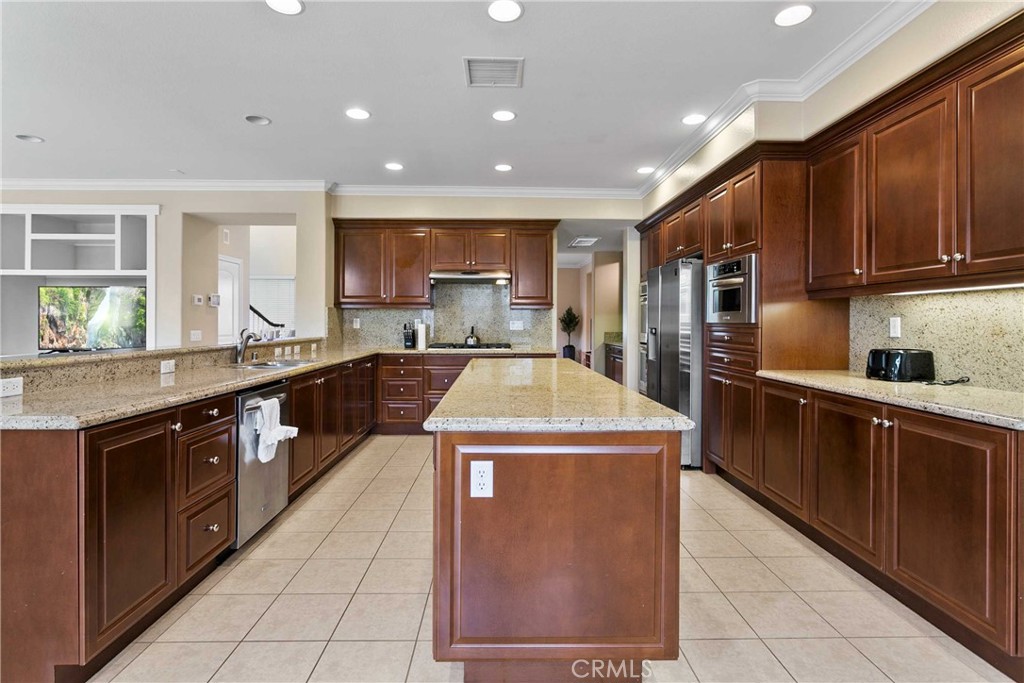 14496 Meadow Brook Eastvale, CA 92880 - Photo 10 of 33 a kitchen with stainless steel appliances granite countertop a sink a stove and a refrigerator