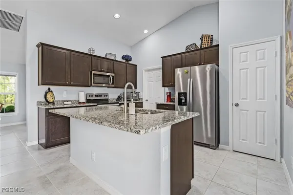 a kitchen with stainless steel appliances granite countertop a refrigerator and a sink