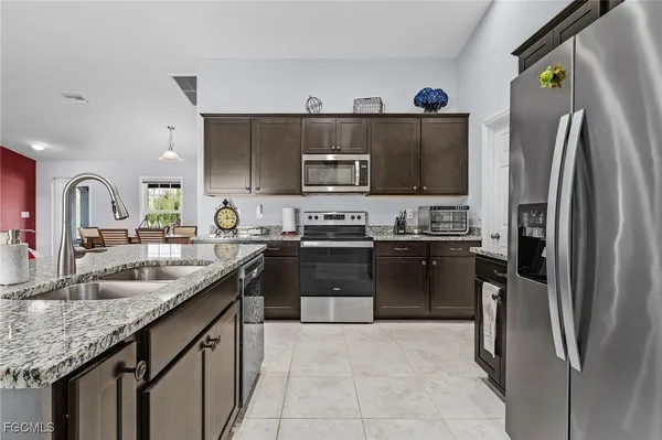 a kitchen with stainless steel appliances granite countertop a refrigerator and a sink