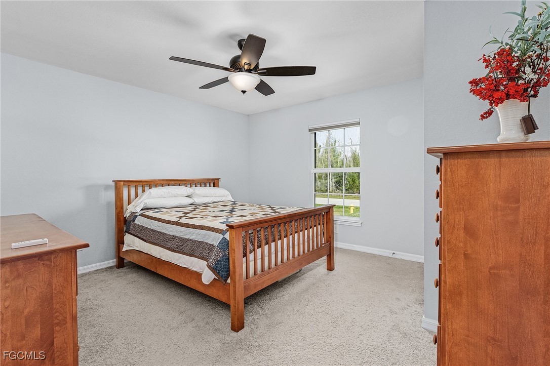 3505 Mango Street St. James City, FL 33956 - Photo 15 of 32 a bedroom with a bed and a chandelier