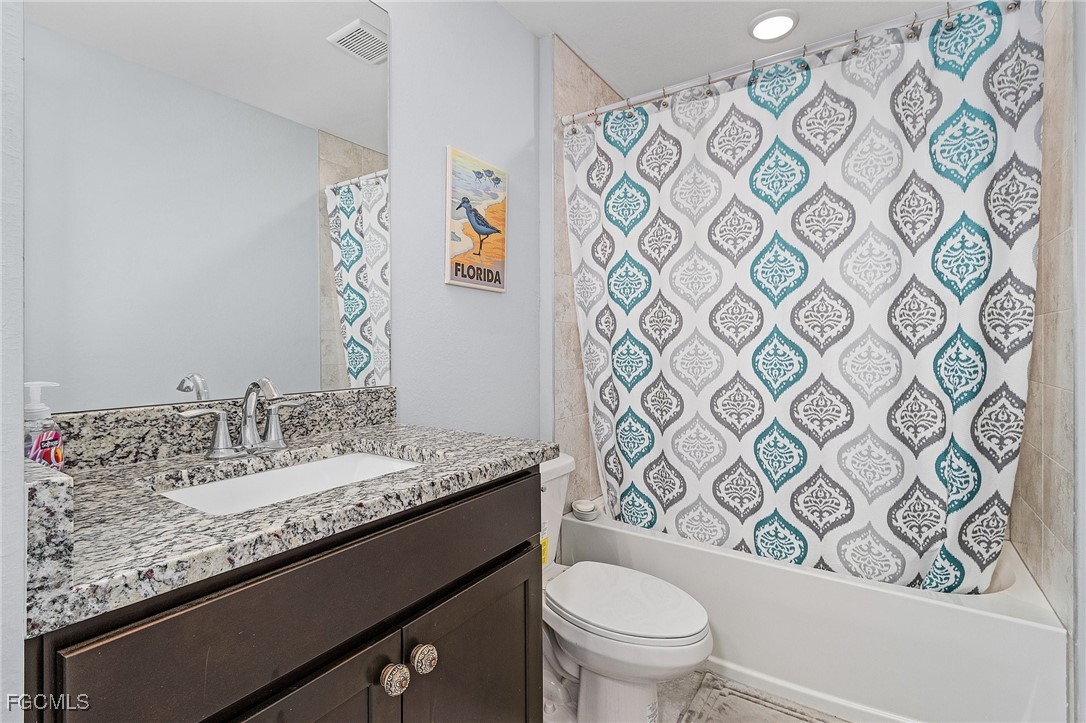 3505 Mango Street St. James City, FL 33956 - Photo 16 of 32 a bathroom with a granite countertop sink and a mirror
