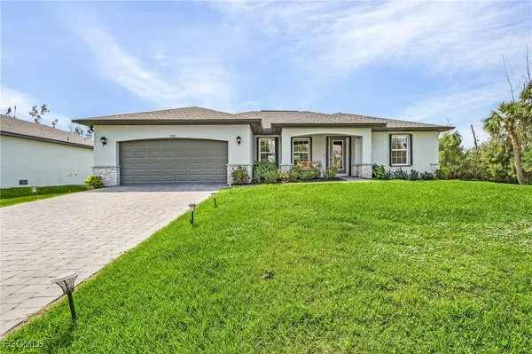 a front view of a house with a garden and yard