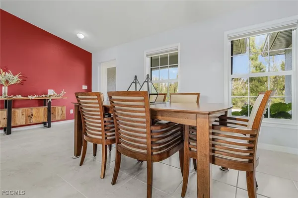 a dining room with furniture and a floor to ceiling window