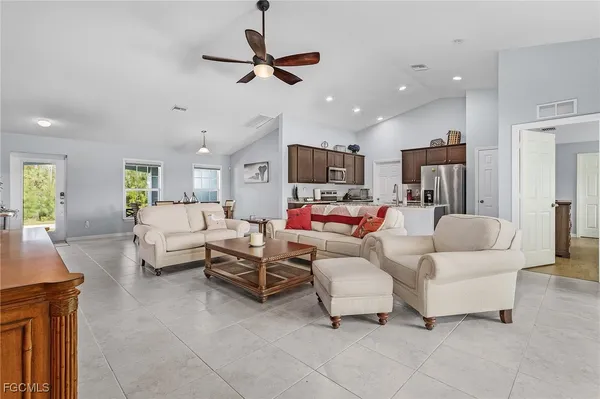 a living room with furniture and kitchen view