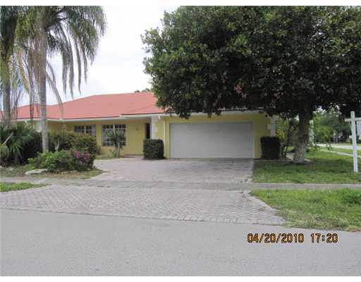 898 Southwest 15th Street Boca Raton, FL 33486 - Photo 1 of 16 a front view of a house with a yard and a garage