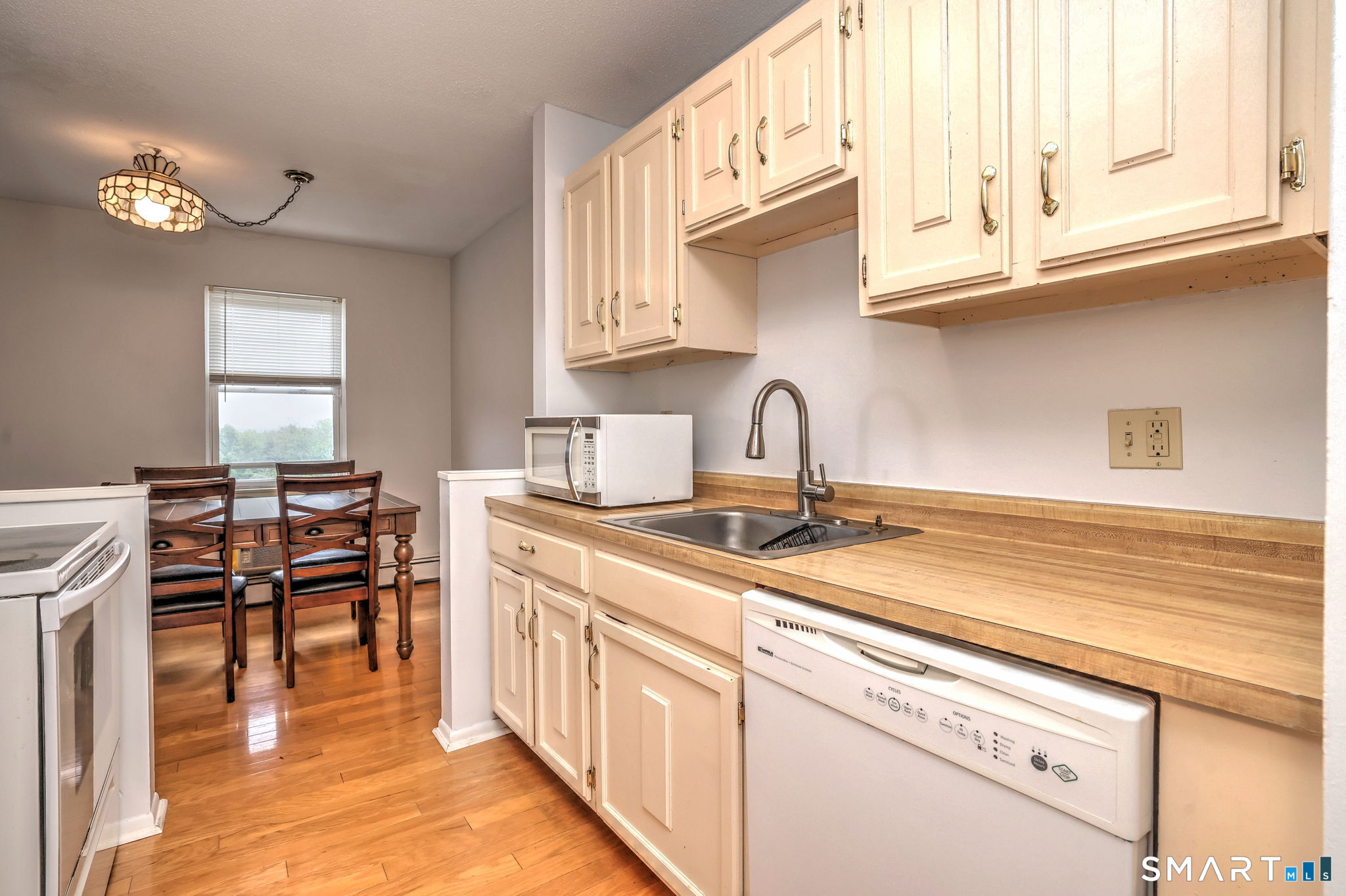 43 Balance Rock Road, Unit 11 Seymour, CT 06483 - Photo 10 of 40 a kitchen with stainless steel appliances granite countertop a sink dishwasher a stove and white cabinets with wooden floor