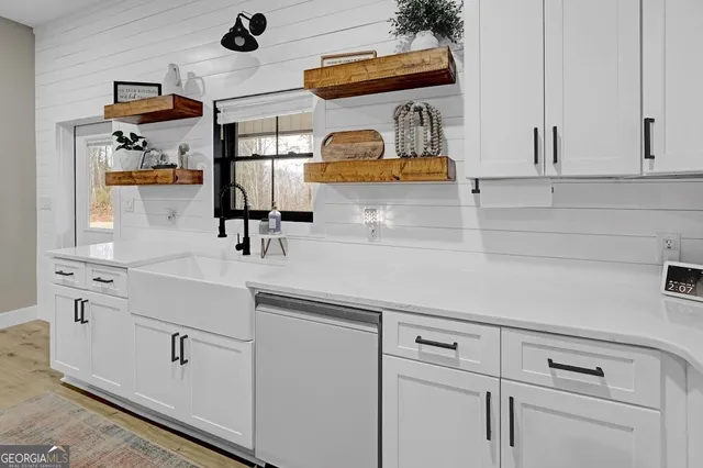 a kitchen with stainless steel appliances white cabinets a sink stove and refrigerator