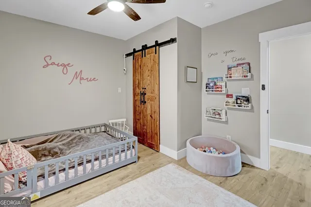 a bedroom with a bed and wooden floor