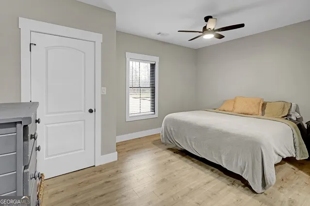 a bedroom with a bed and painting on the wall