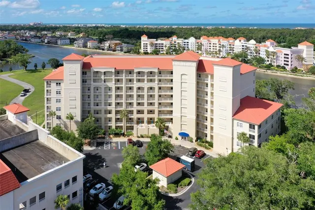 an aerial view of a city with lots of residential buildings ocean and mountain view in back