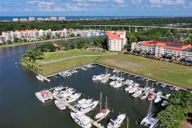 an aerial view of a city with lots of residential buildings ocean and mountain view in back