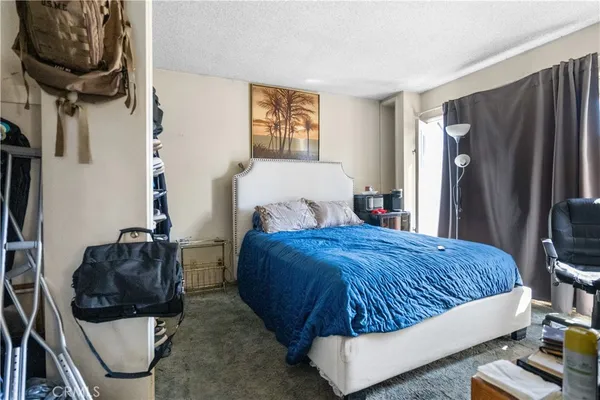 a bedroom with a bed a couch and dresser