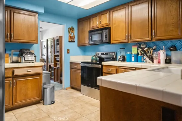 a kitchen with stainless steel appliances granite countertop a refrigerator stove top oven a sink and dishwasher