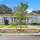 a view of a house with a backyard and a tree