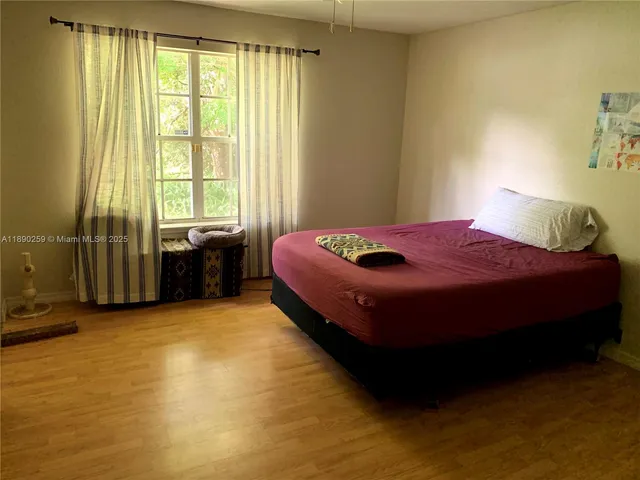 a spacious bedroom with a bed and a window