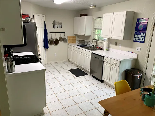 a kitchen with a refrigerator and a stove top oven