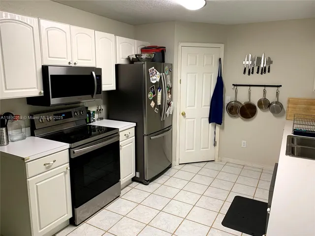 a kitchen with stainless steel appliances a refrigerator sink and microwave