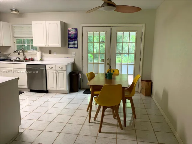 a kitchen with a sink a stove cabinets and dining table