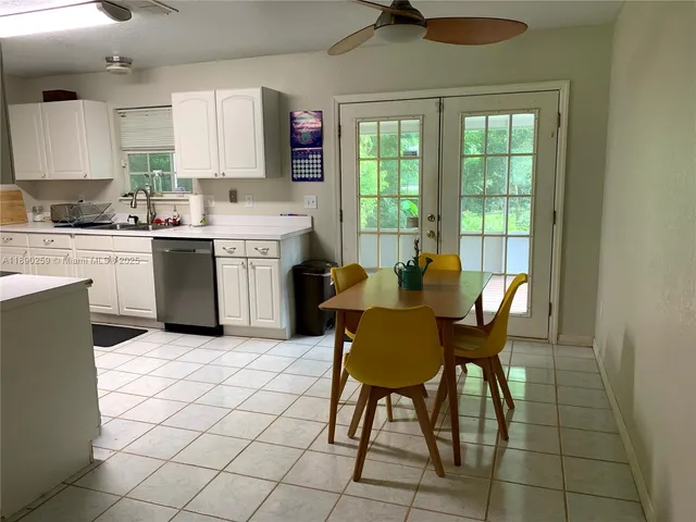 a kitchen with a dining table chairs and white appliances
