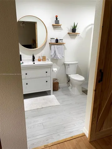 a bathroom with a sink vanity granite and a toilet