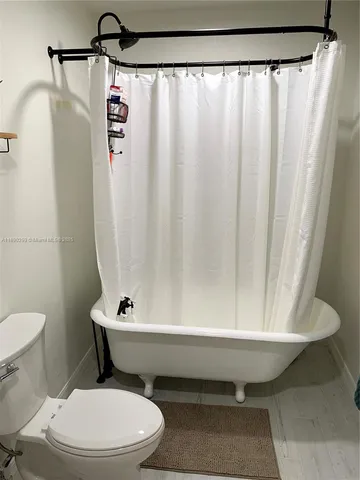 a bathroom with a toilet and a shower curtain