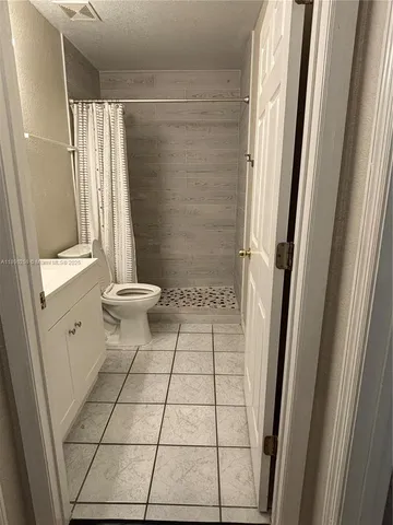 a bathroom with a sink a toilet a window and shower