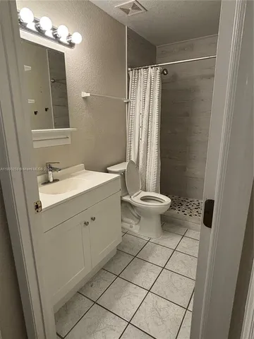 a bathroom with a sink a toilet a mirror and shower
