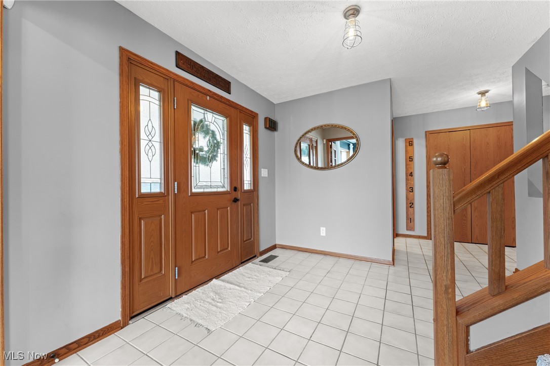 645 Killinger Road Clinton, OH 44216 - Photo 16 of 50 Foyer with light tile patterned flooring and a textured ceiling