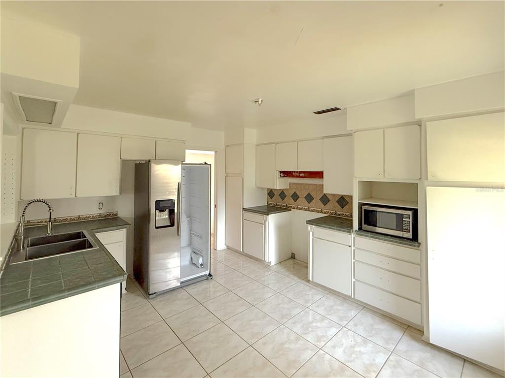 2464 Derbyshire Road Maitland, FL 32751 - Photo 18 of 42 a kitchen with a refrigerator sink and stove top oven