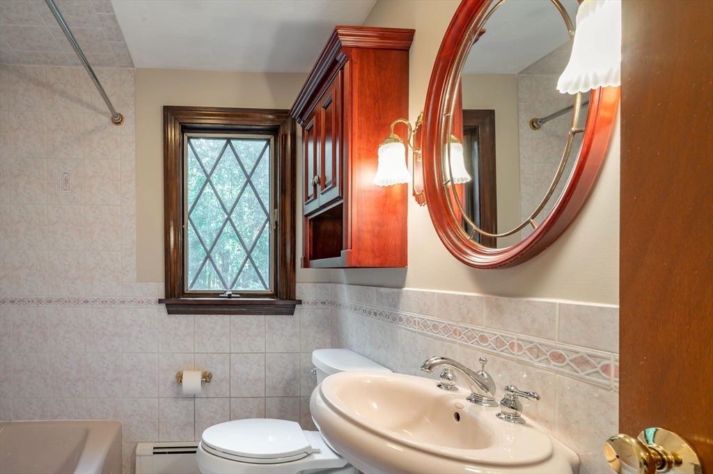 41 Marcus Road Wilmington, MA 01887 - Photo 14 of 29 a bathroom with a sink a mirror and a toilet