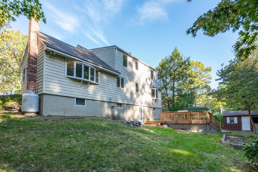 41 Marcus Road Wilmington, MA 01887 - Photo 25 of 29 a backyard of a house with wooden fence and large trees