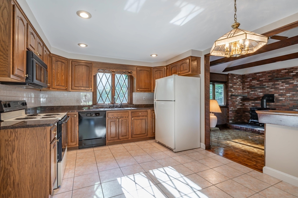 41 Marcus Road Wilmington, MA 01887 - Photo 7 of 29 a kitchen with refrigerator and cabinets