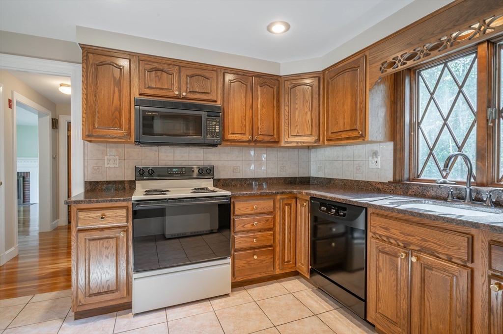 41 Marcus Road Wilmington, MA 01887 - Photo 8 of 29 a kitchen with stainless steel appliances granite countertop a stove microwave and cabinets