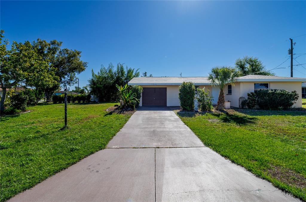 a front view of a house with a yard and potted plants