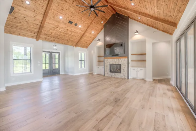a view of empty room with wooden floor and fireplace
