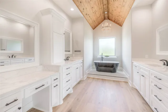 a spacious en suite bathroom with a double vanity sink and a mirror