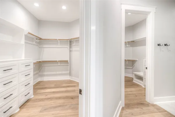 a walk in closet with white walls