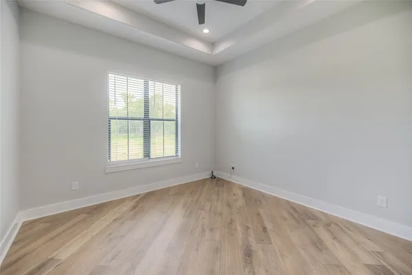 an empty room with a window and a ceiling fan